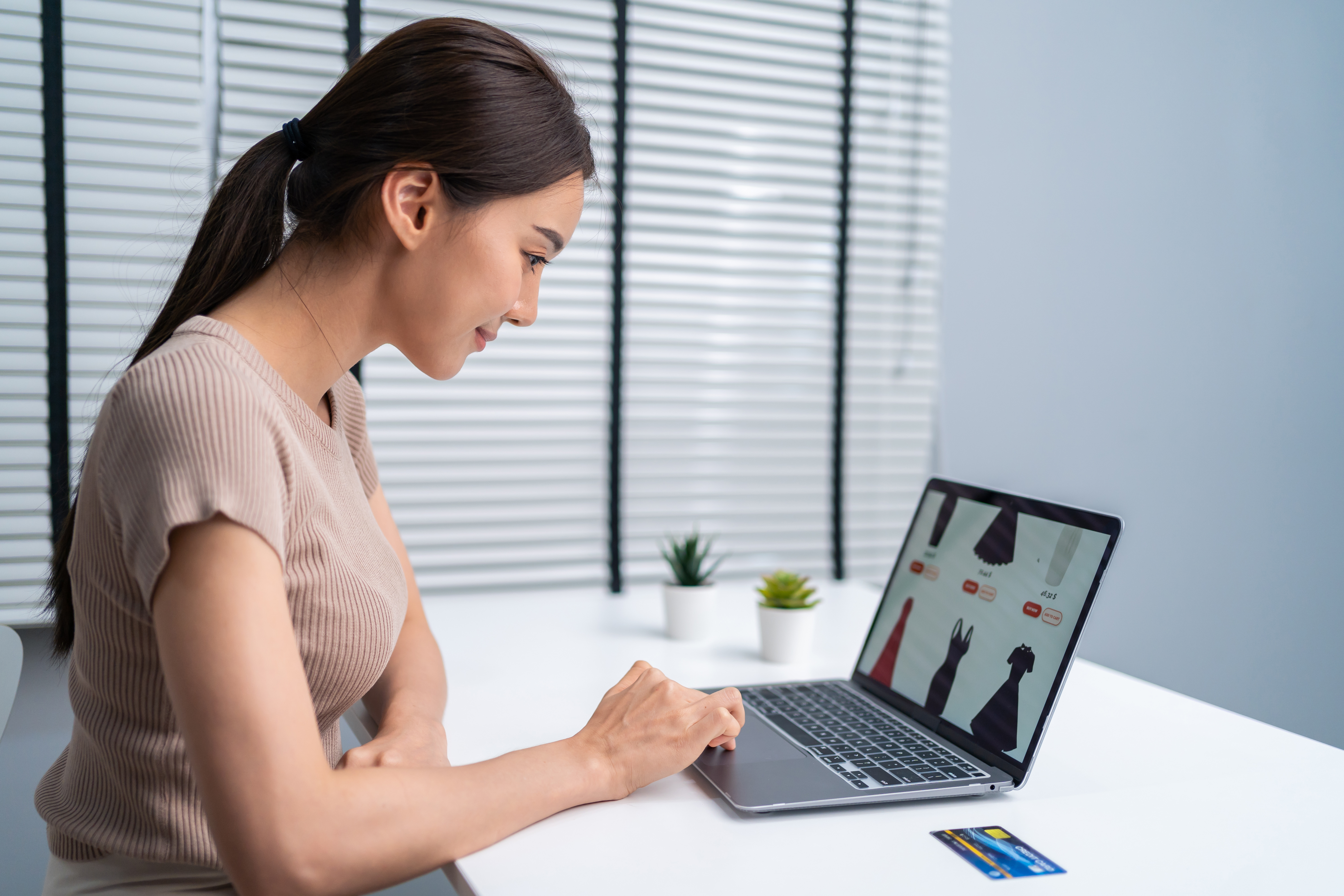 Business owner attending an online meeting while reviewing a company website on a laptop.